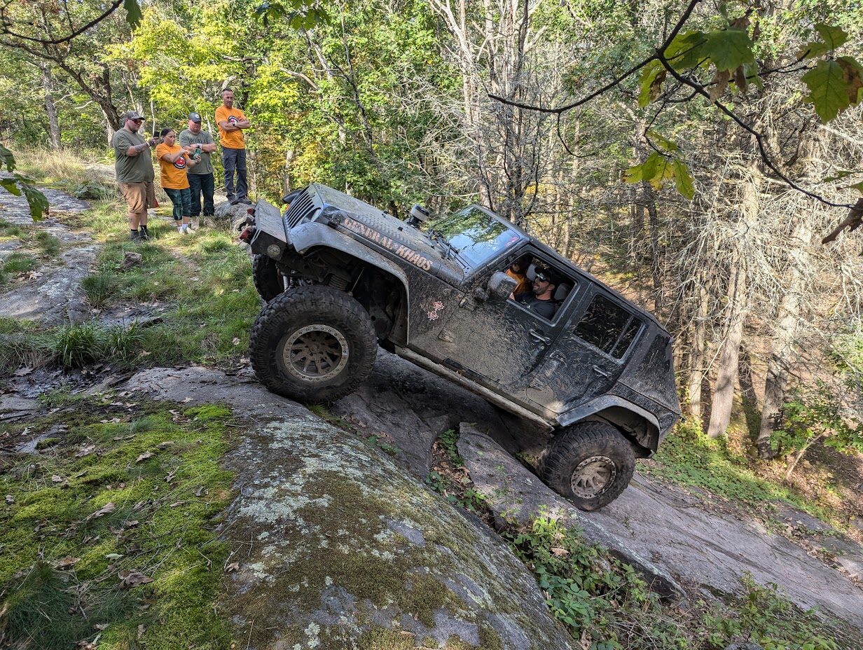 A rig working a rocky obstacle on the trail
